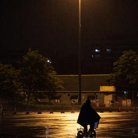 雨夜出去扫街，路边的一根路灯黄色的灯光洒在落雨的马...