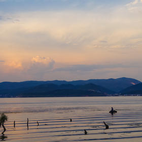 环洱海骑行时拍摄的，夕阳西下，渔舟、游船相互辉映，...
