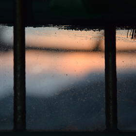 透过窗户拍摄的落日余晖，农村灰蒙蒙的窗子倒是添了一...