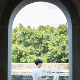 到深圳大鹏古城游玩，看到窗口外一个男孩正在认真的画...