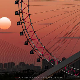 取景：
站在桥上看到远方的落日余晖映射在摩天轮上，...