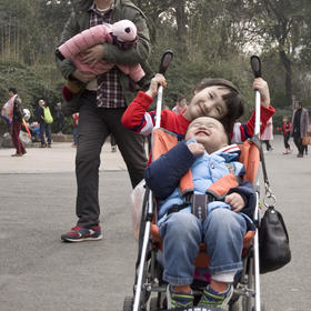 取景：动物园内一小女孩推着婴儿车，弟弟坐在车上，两...