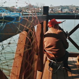 取景：沿河公园一位老人在钓鱼。这个渔网和光影看着都...