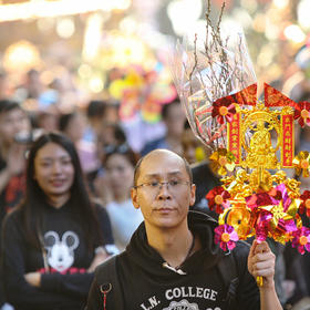 取景：广州花市中，手持祈福金牌的男子。

曝光：正...