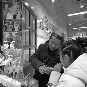 取景：2018年春节，北京大栅栏商业区，吹糖人的师傅在...