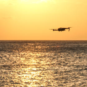 取景：在海边拍日落时，刚好看到一家无人机飞过，立刻...