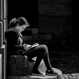 取景：一位年轻姑娘坐在台阶上专注地写着东西。
曝光：...