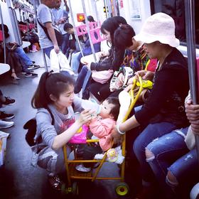 取景：手机广角抓拍，一位母亲在地铁喂孩子的一个场景...