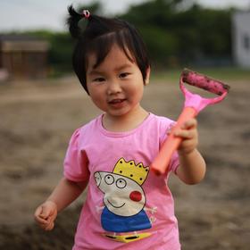 取景：在公园湖边的沙地上，女儿捡起一个断掉的铲子玩...