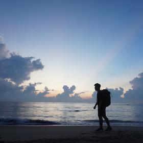 一人独自来到海南看海，想看看海上日出，拍下了这张背...