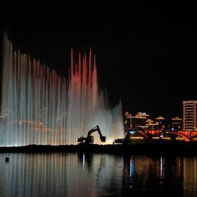 取景：一个江心岛公园，喷泉广场后侧还在施工，以喷泉...