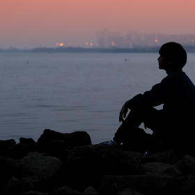 暖色的夕阳，蓝蓝的大海，一个人，独坐于礁石，遥望远...