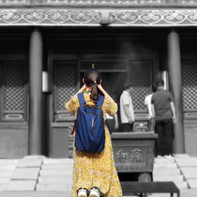 雍和宫，一位正在祈祷的姑娘，明黄色的裙子在红色的寺...