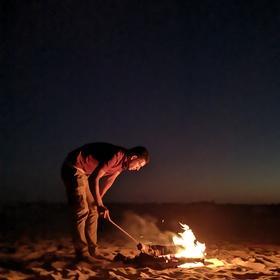 在埃及撒哈拉沙漠露营的傍晚，抓拍下了点燃篝火的一瞬...