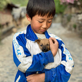 丽江玉龙雪山脚下，路遇小朋友，他刚找到一只小奶狗，...
