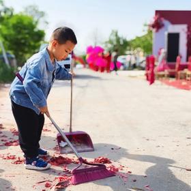 在婚礼现场附近，看到一个小孩在认真地打扫地面上的礼...