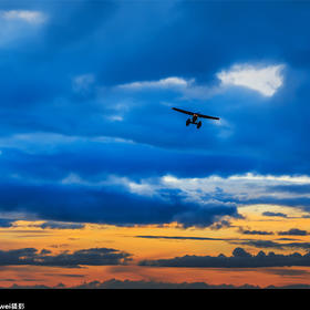 厚得湖水上机场，落日余晖下一架小型运动飞机即将降落...